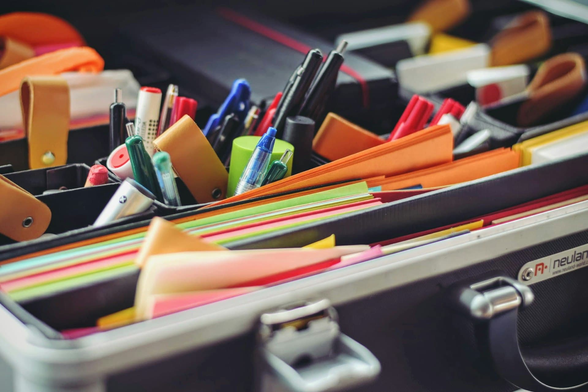 Pens, markers and coloured paper arranged in a case
