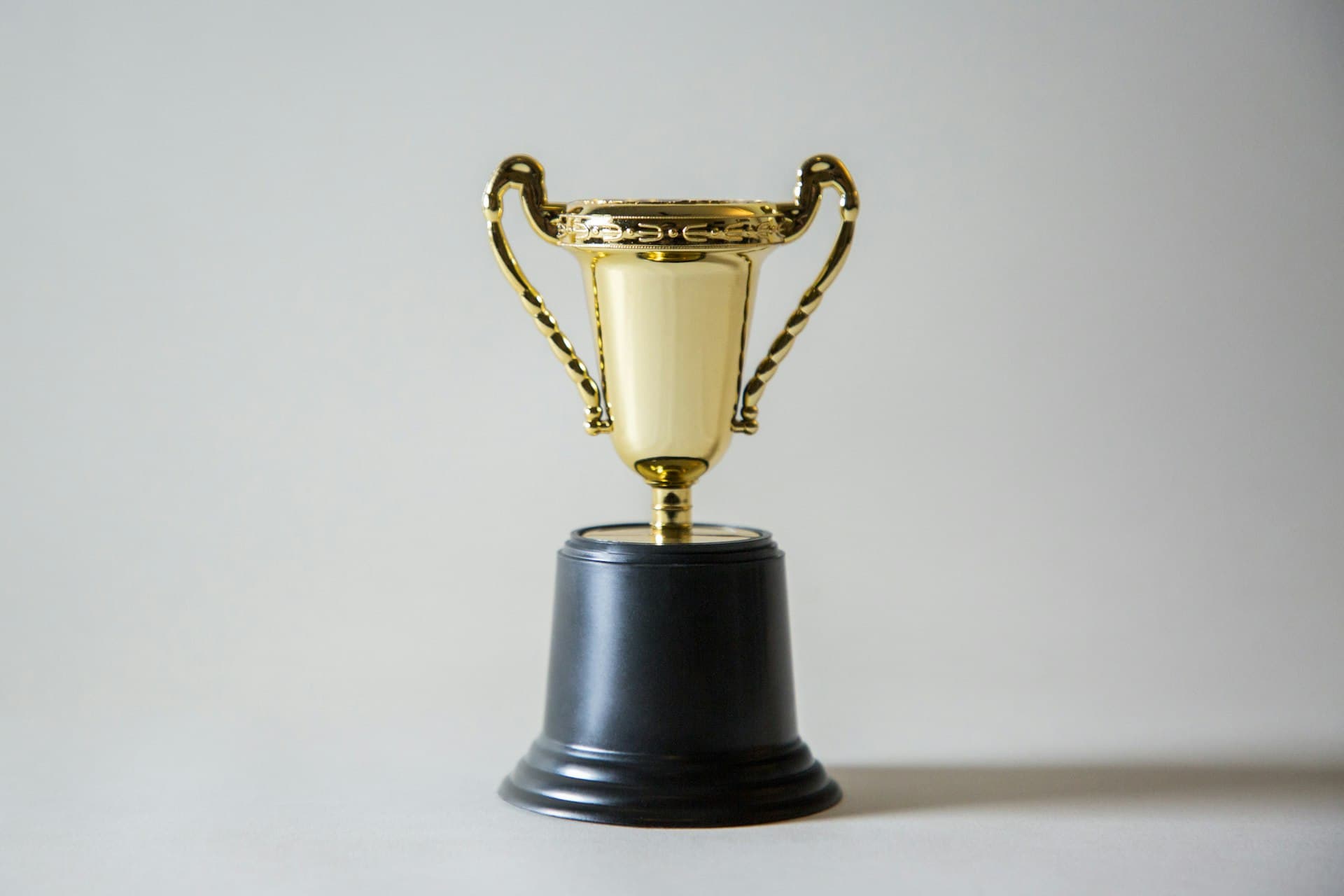 A gold winner's trophy on a black base