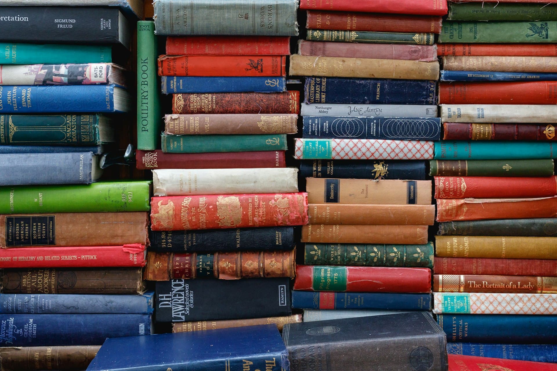 A close-up of stacked vintage hardback books